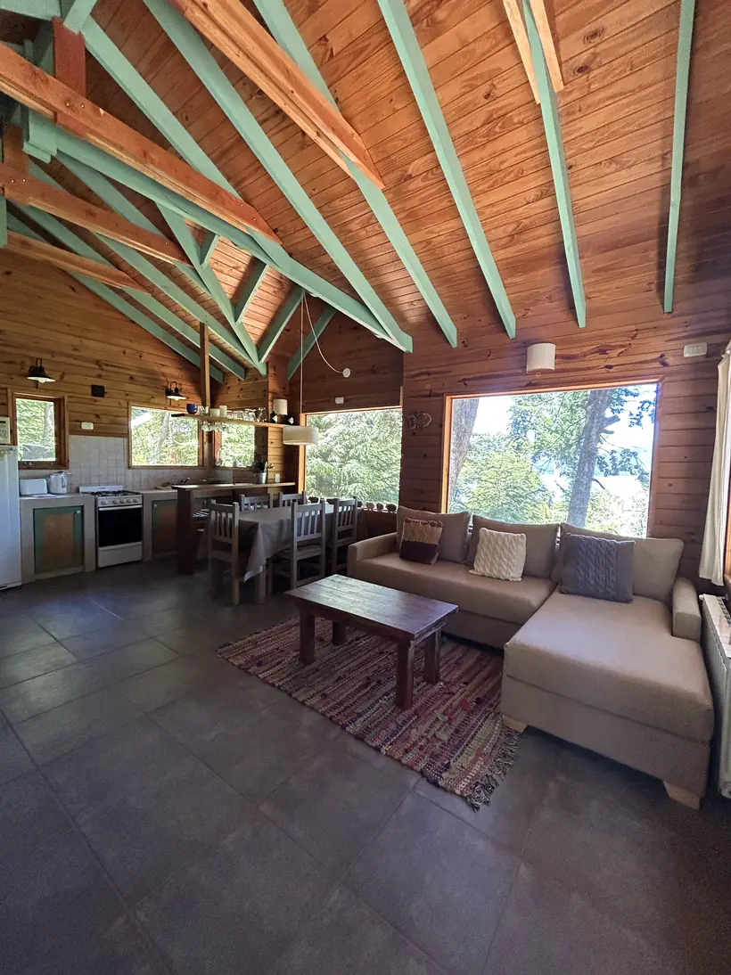 Living con techo alto de madera y ventanales