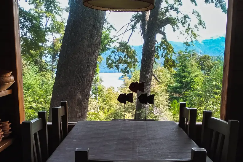 Mesa del comedor con vista al lago entre los árboles